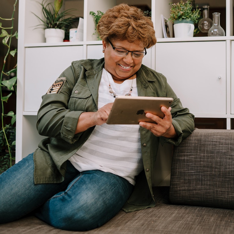 Woman uses tablet device at home