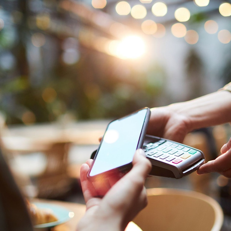 Person tapping phone on card reader.