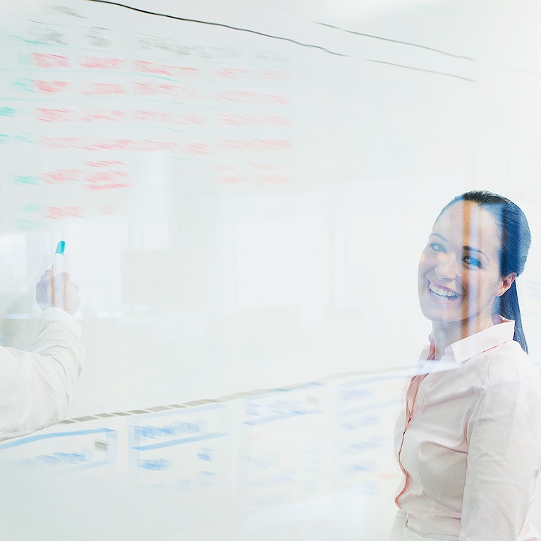 Business people brainstorming at whiteboard in office