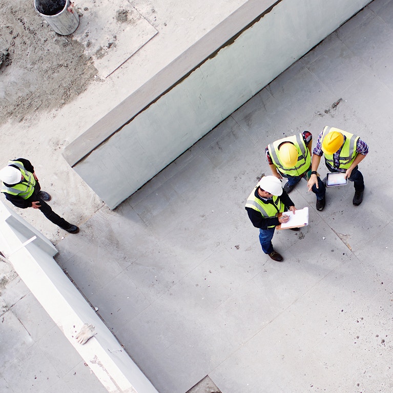 Overhead view of construction workers and engineers at construction site