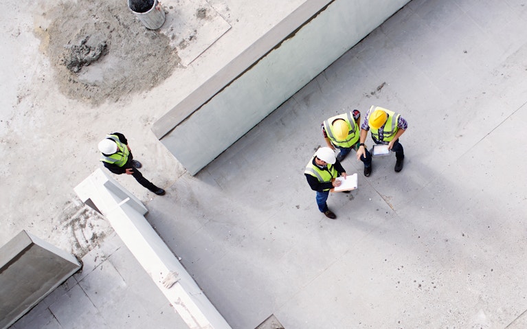 Overhead view of construction workers and engineers at construction site