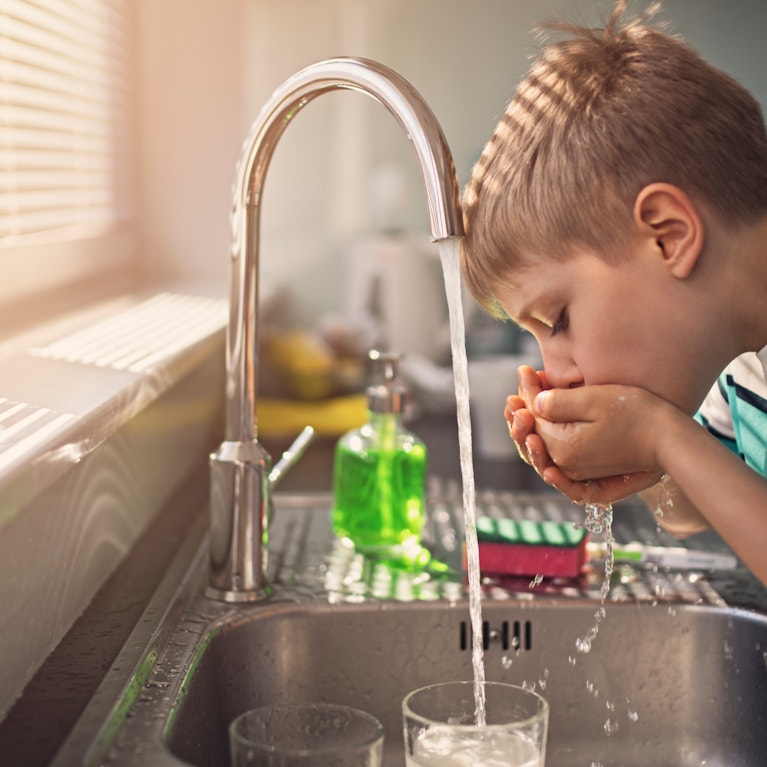 Little boy drinking tap water