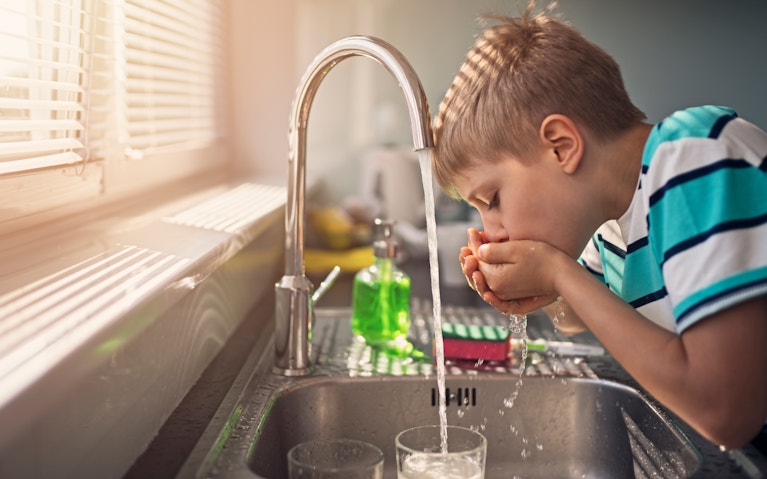 Little boy drinking tap water