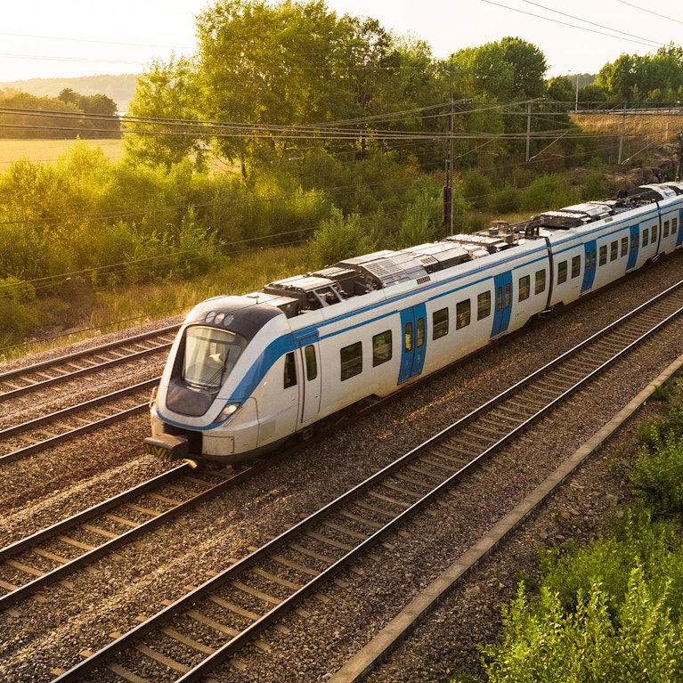 Passenger train on tracks through countryside