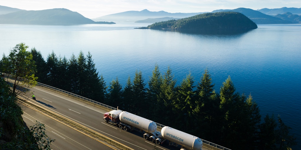 Hydrogen tanker truck driving on lakeside highway