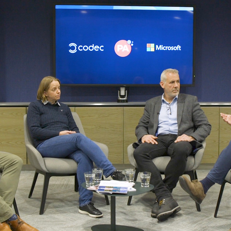 Four people in conversation in a meeting room