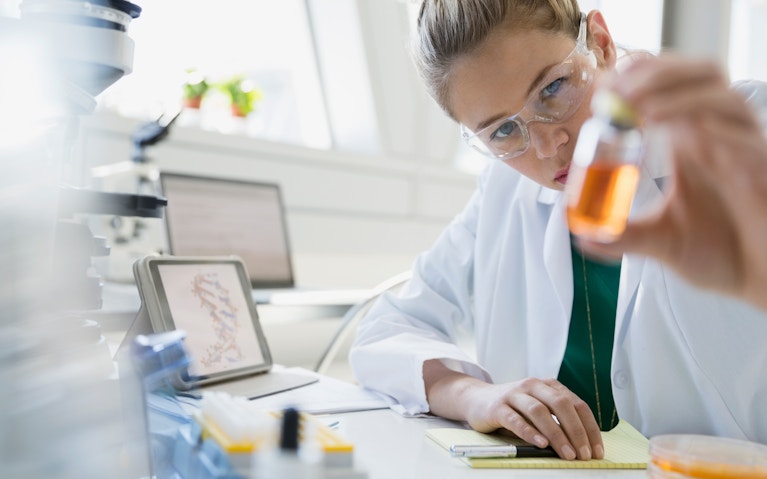 Scientist examining liquid in jar