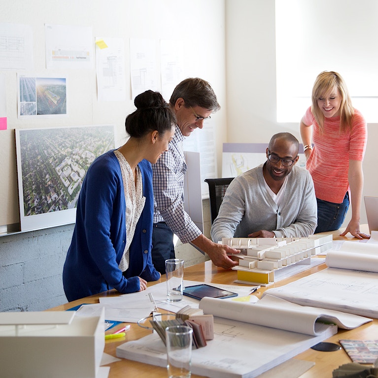 Business people discussing blue prints in office