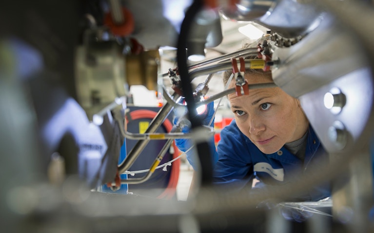 Female helicopter mechanic examining wires