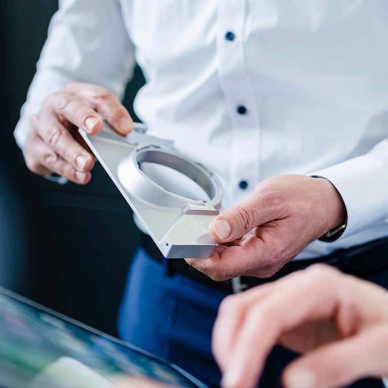 Close-up of businessman and businesswoman with product and tablet having a work meeting