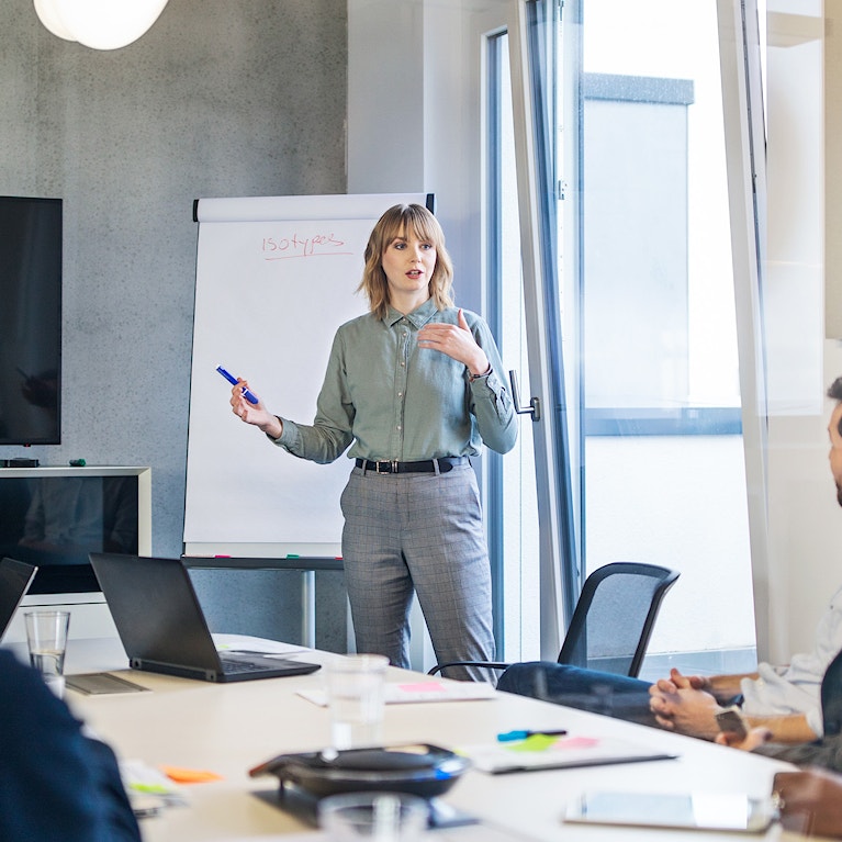 Businesswoman addressing a meeting around board table