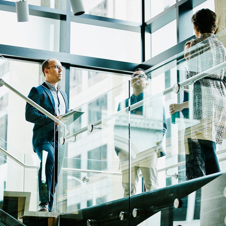 Business colleagues in discussion on office stairs