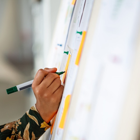 Woman adding notes to whiteboard