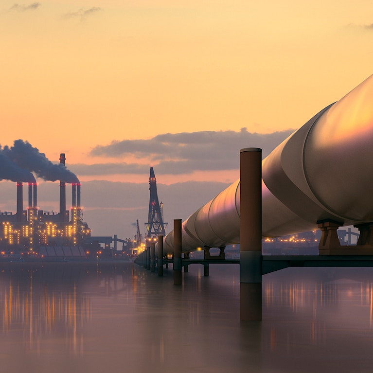 Oil pipeline in industrial district with factories at dusk