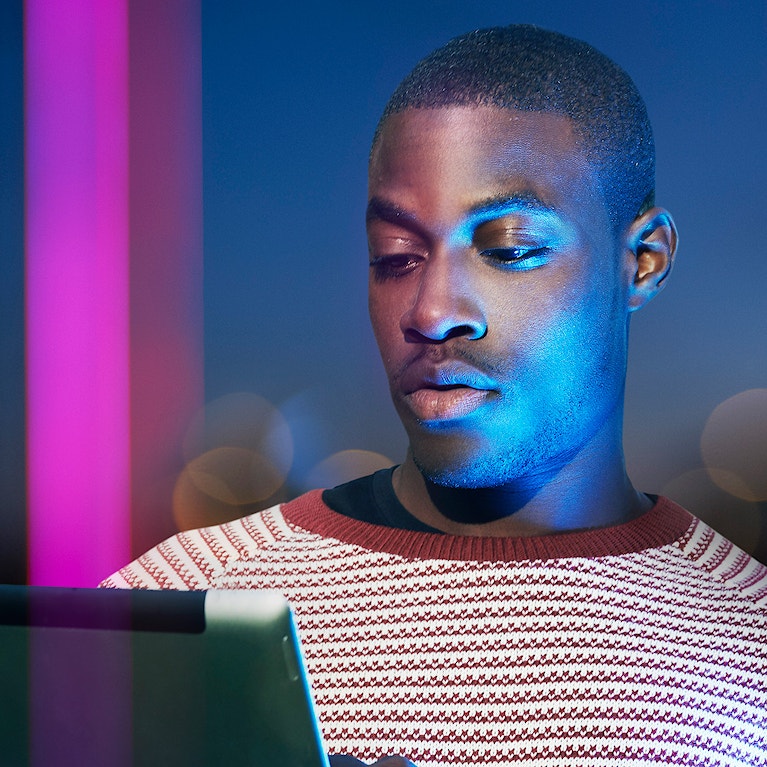 A person using a digital tablet at night in the city