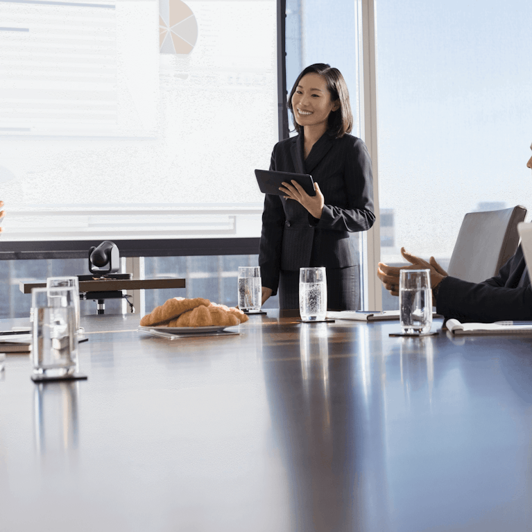 Five professionals in conversation during a meeting